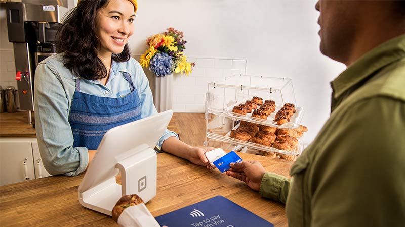 A customer paying contactless, one of the payment processing systems for small businesses